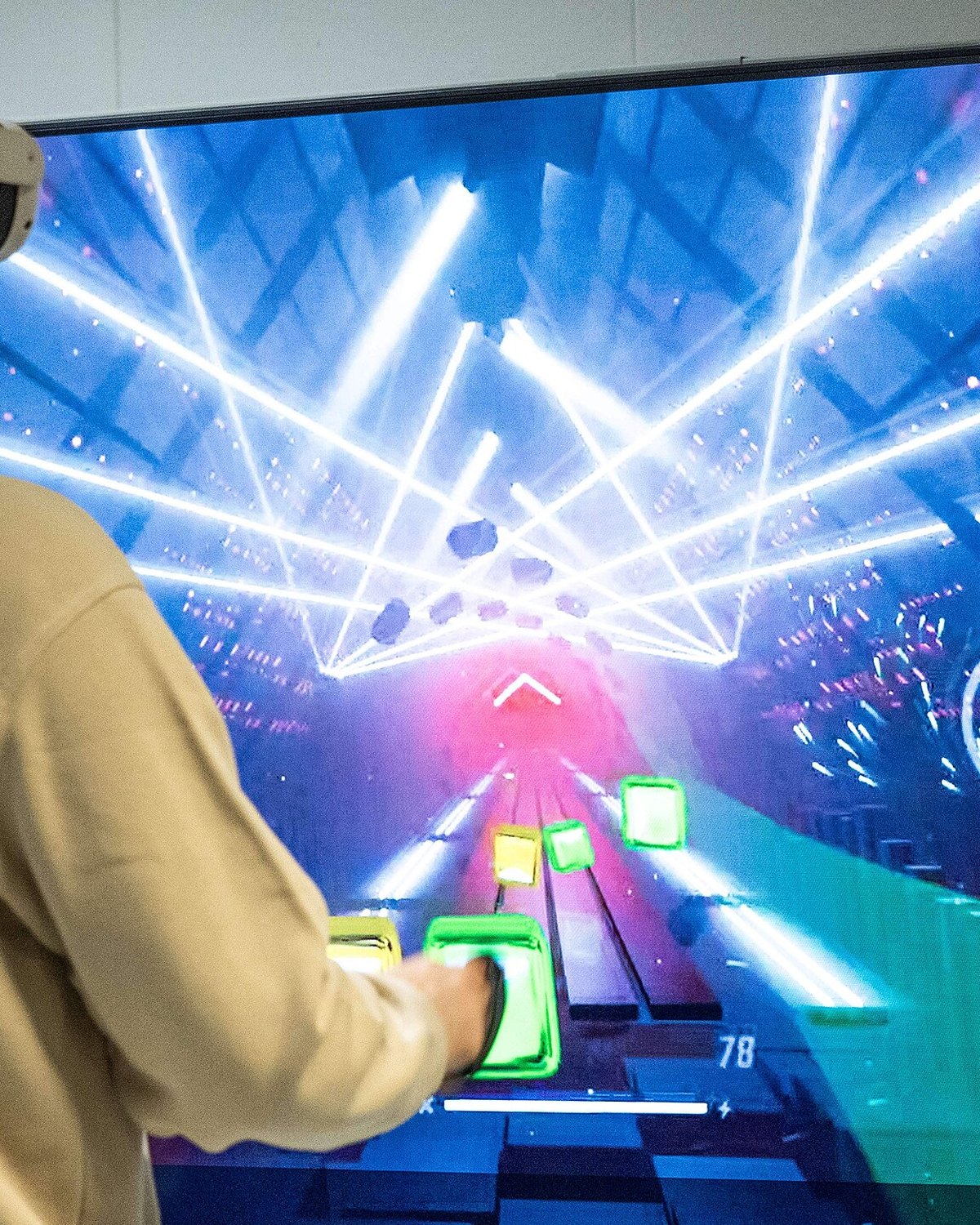 Focused player wearing a VR headset in the neon-lit IRLESS hybrid arena, mid-session